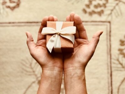 person s holds brown gift box