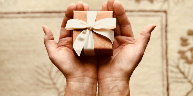 person s holds brown gift box