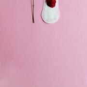 red rose and menstrual pad on pink background