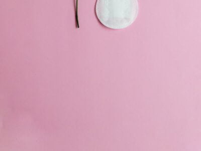 red rose and menstrual pad on pink background