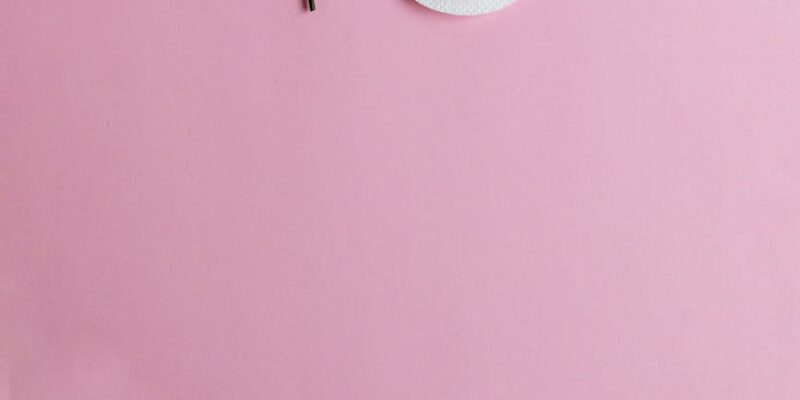 red rose and menstrual pad on pink background