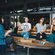 four women chatting while sitting on bench