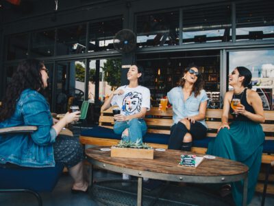 four women chatting while sitting on bench