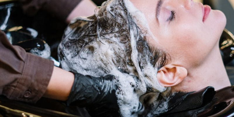 person washing woman s hair